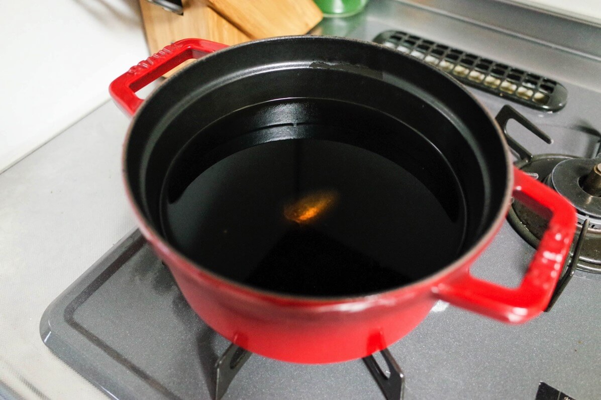 鍋の中に鉄玉子と黒豆を入れる